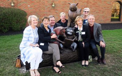 Library director and Board members pose with sculpture