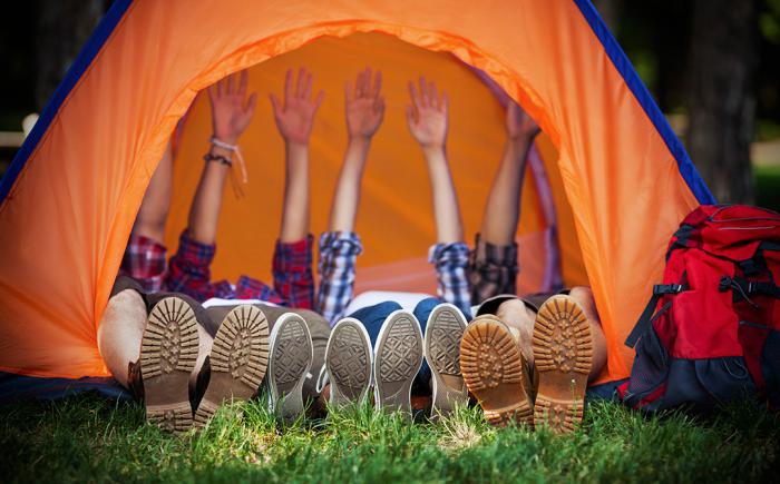 People lying in a tent raising both arms