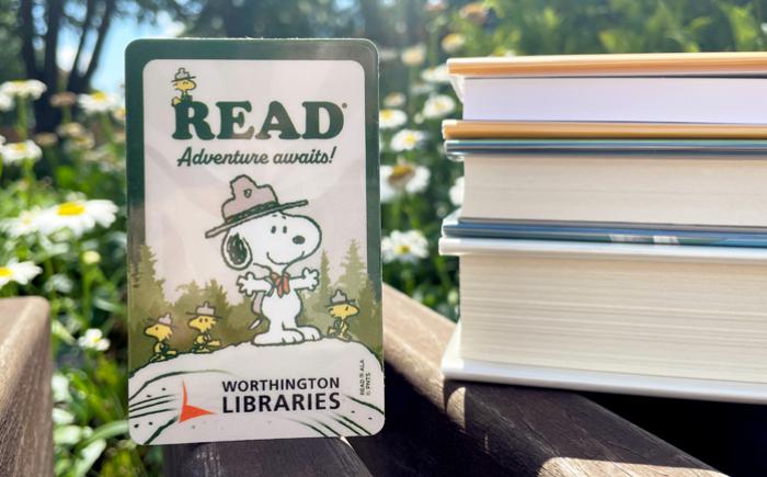 Snoopy library card next to a stack of books