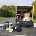 Cargo area of large truck is full of boxes; truck is surrounded by computer equipment