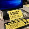 Computer with sign that reads 'Computer Reserved for persons with low vision"