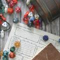 Tabletop board game die, pouches and character sheet