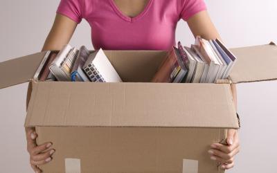 Woman holding a box partially filled with books