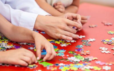 Hands assembling a jigsaw puzzle