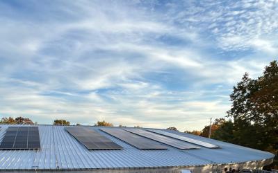 Solar panels on library roof with blue sky and streaks of clouds