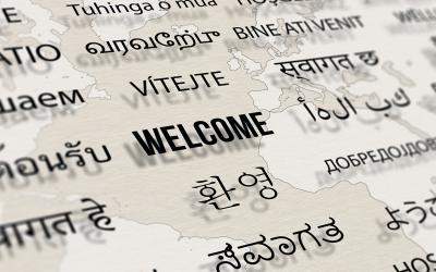 "Welcome" in multiple languages against a world map